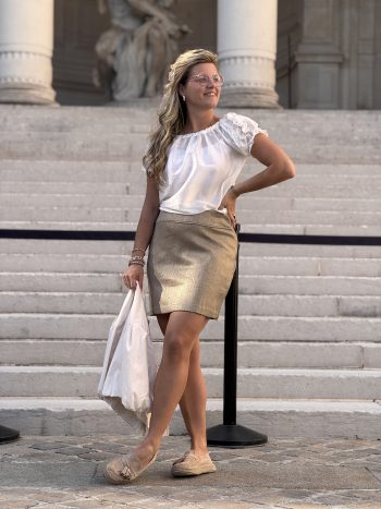 Janita rok goud, gedragen met wit shirt en beige schoenen op trappen