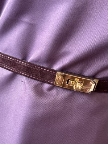 Hannelore tas choco met bruine leren schouderband en goudkleurige gesp op paars ondergrond