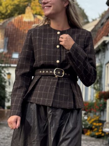 Suedeline rok tan in tan/beige suède, getragen met geruit zwart jasje en riem met gesp, voorkant zichtbaar