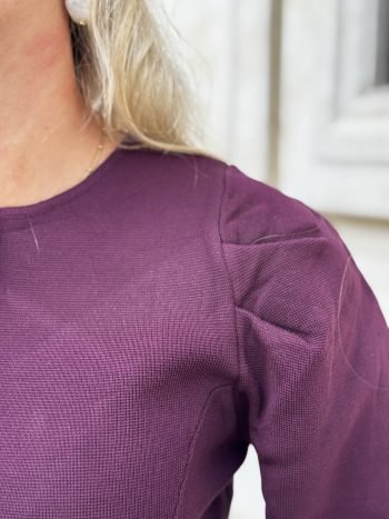 Lizalau satin dress taupe, close-up van de schouder en bovenkant, paarse tinten zichtbaar in het satijnweefsel